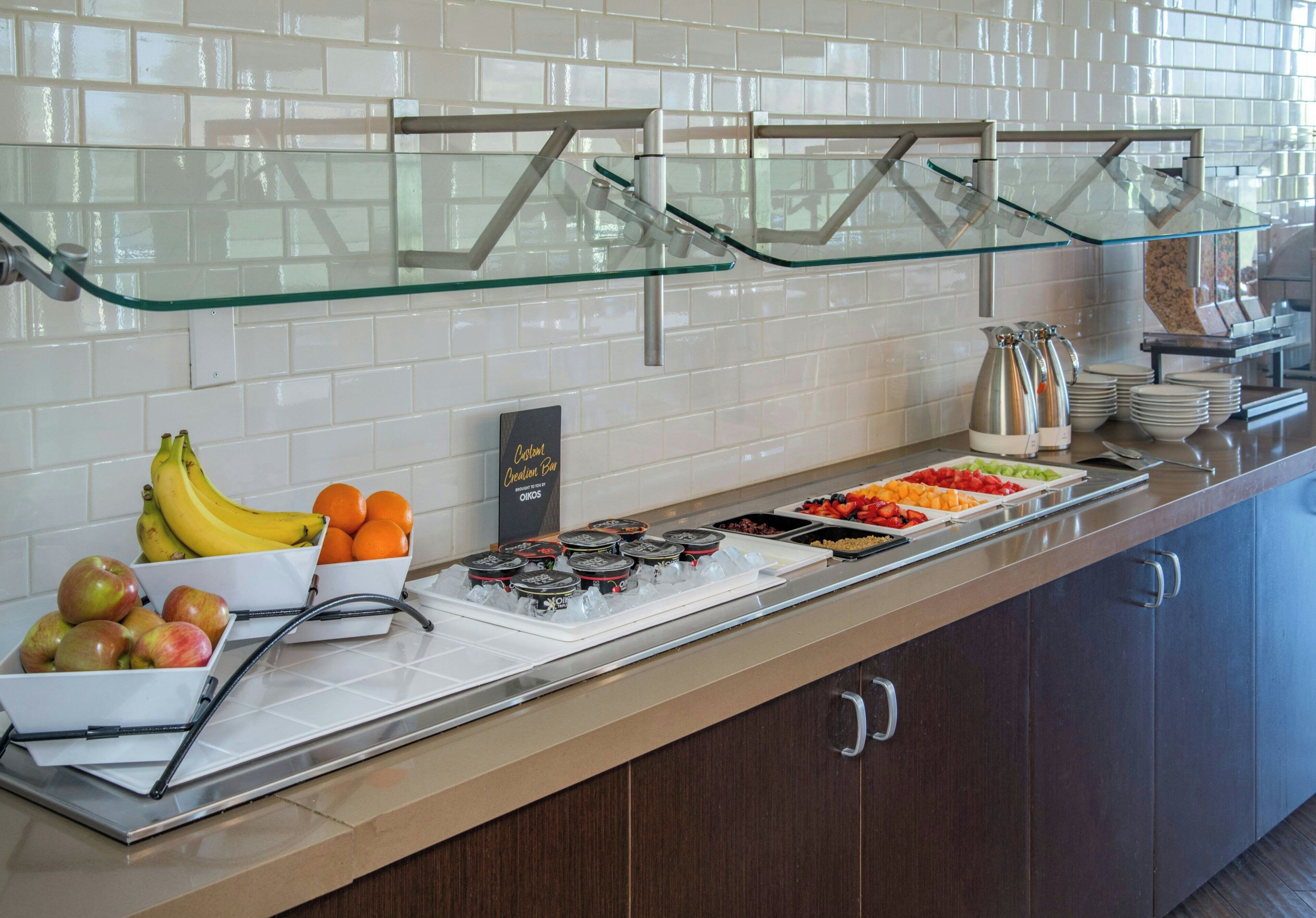 A buffet with various fruits, vegetables, and condiments.