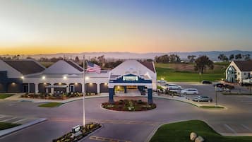 A Staybridge Inn with a prominent American flag, a parking lot, and a view of distant mountains.