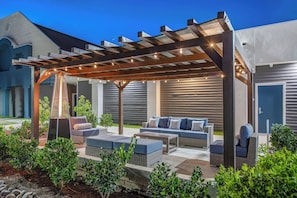 An outdoor patio with a pergola, seating area, and a heated floor. - Staybridge Suites Oxnard River Ridge by IHG (Oxnard)