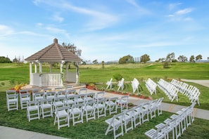 A gazebo with white chairs arranged in rows on a grassy lawn. - Staybridge Suites Oxnard River Ridge by IHG (Oxnard)
