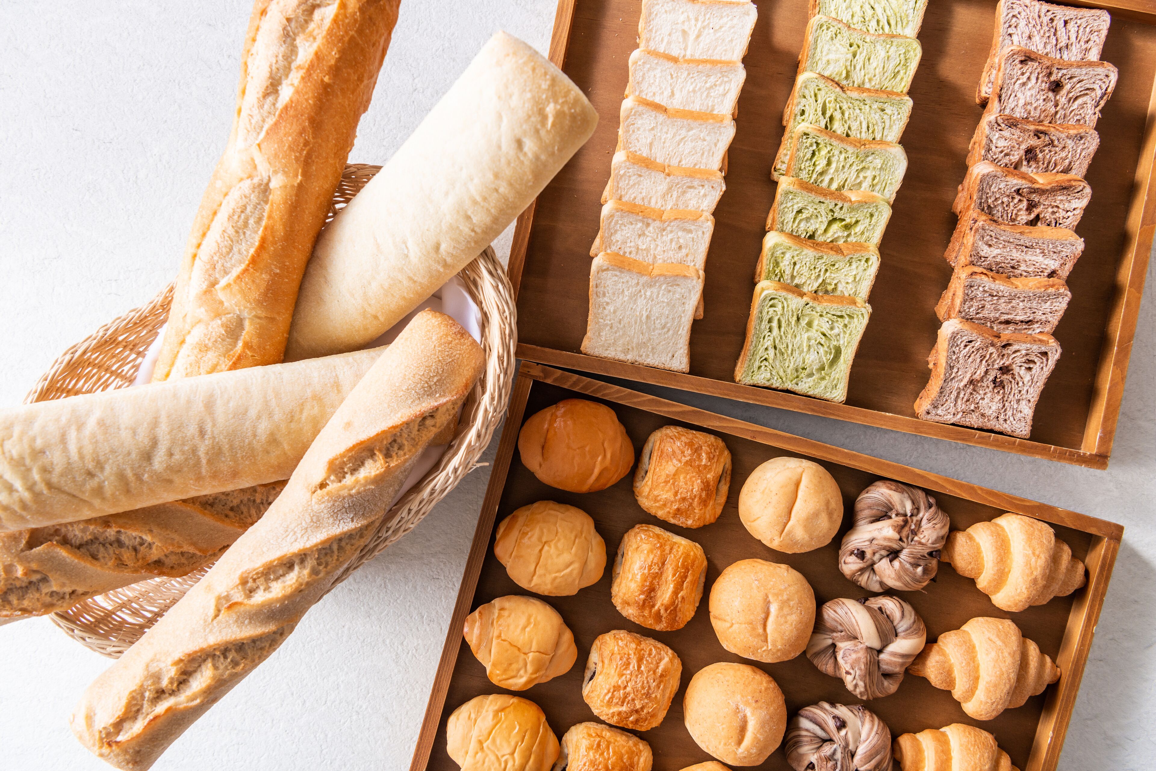 A variety of bread and pastries displayed in baskets and trays.