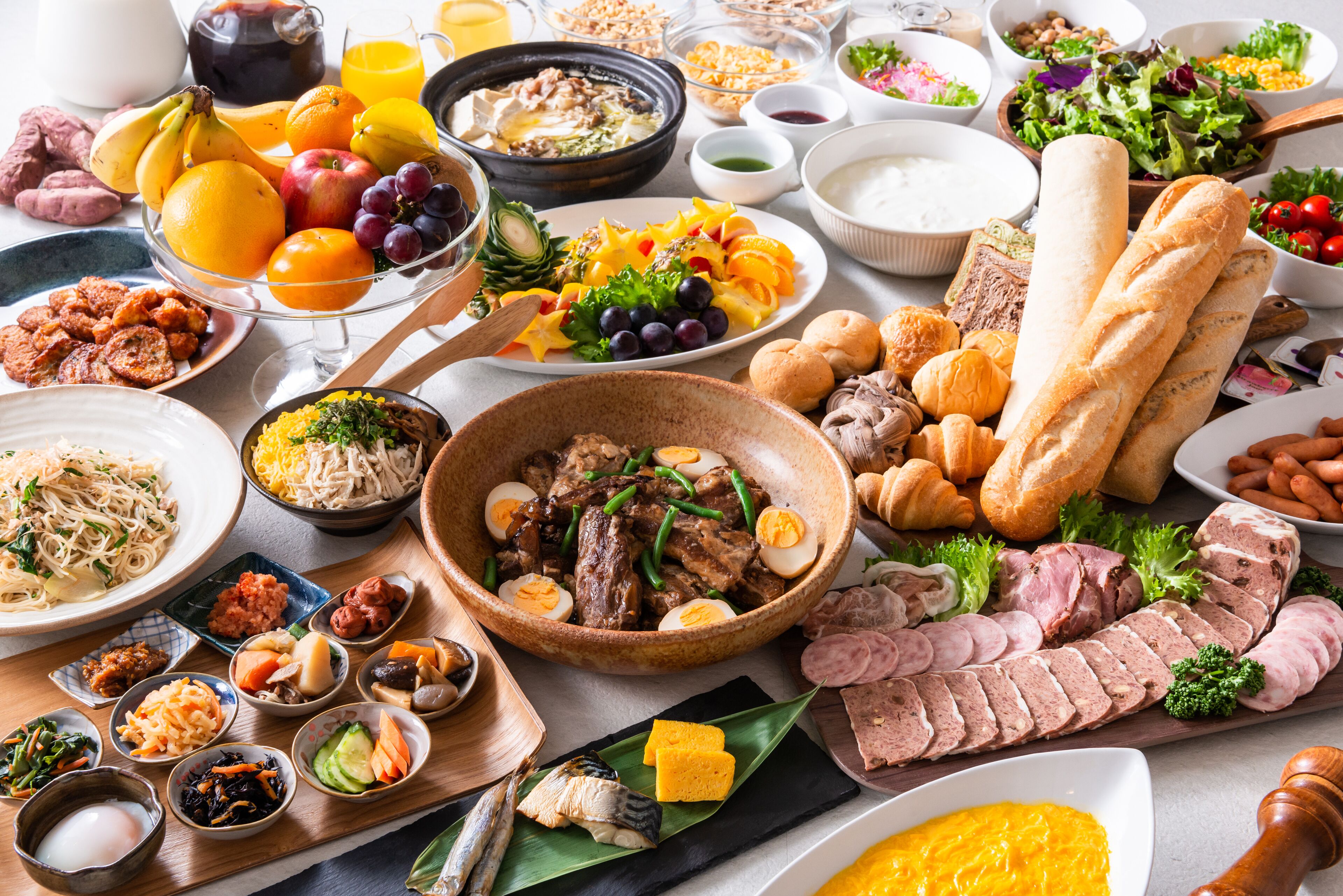 A variety of food items including bread, meats, and vegetables on a table.