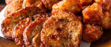 A plate of fried food items, likely fritters or croquettes, with a golden-brown crust.