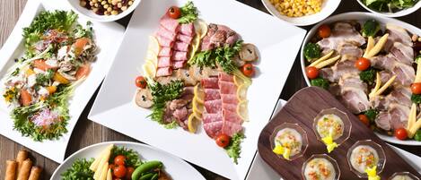 A variety of food items arranged on a table, including meats, vegetables, and salads.