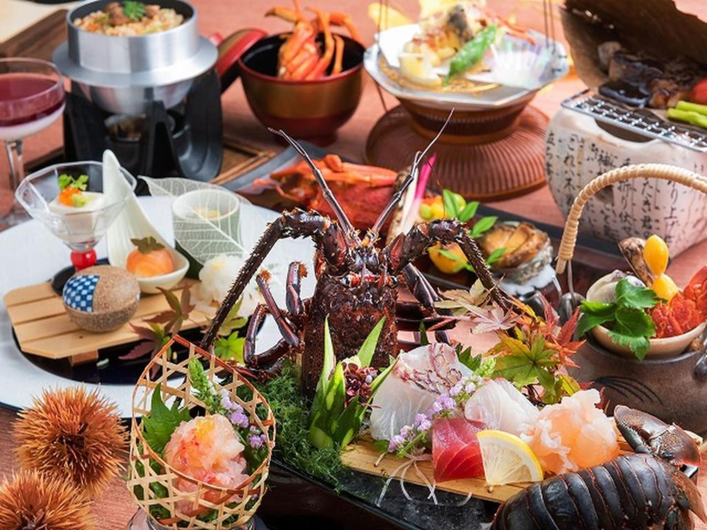 Una bandeja de mariscos con diversos platos, incluyendo langosta, camarones y sashimi.