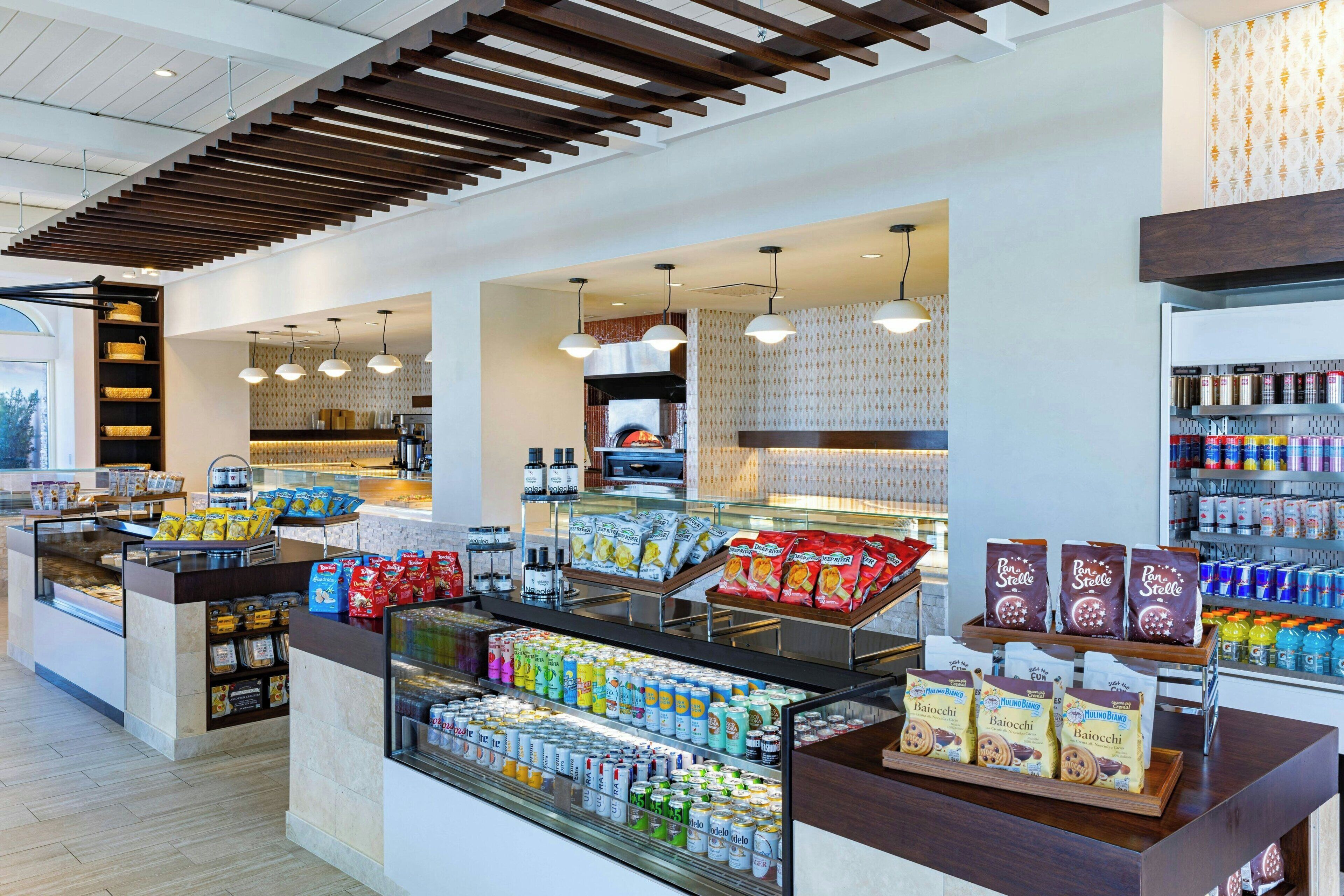 A modern café with a variety of food and drink options, including packaged snacks, beverages, and coffee.