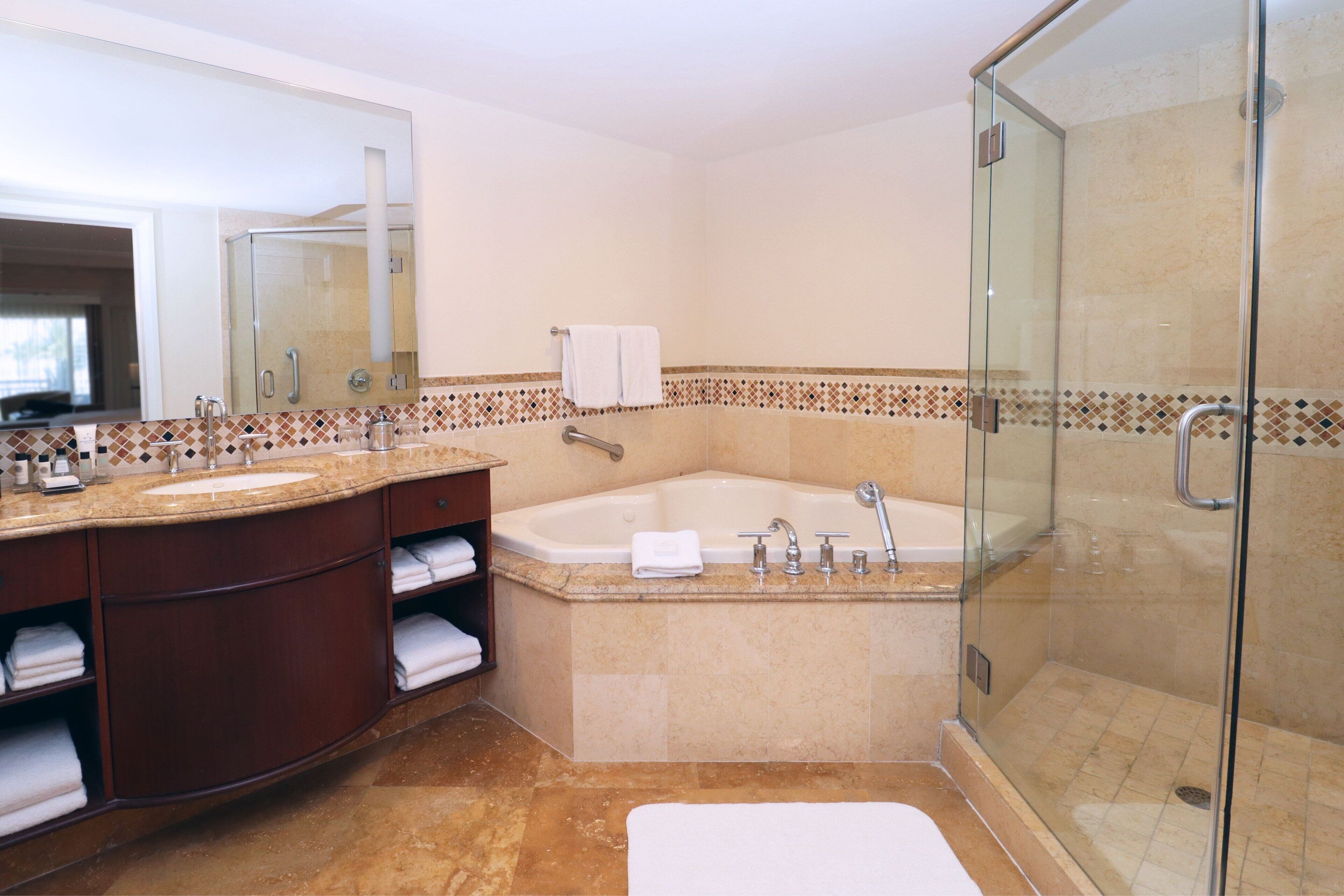 Une salle de bain moderne dotée d’une douche à parois de verre, d’une baignoire sur pieds et d’un meuble-lavabo avec un miroir et un évier.