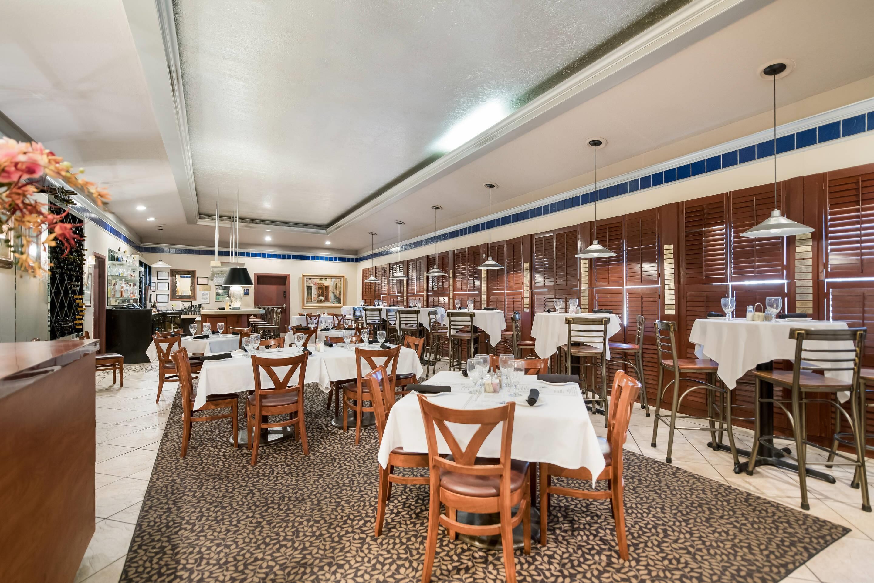 Un restaurant doté de nombreuses tables, de chaises et de luminaires suspendus.