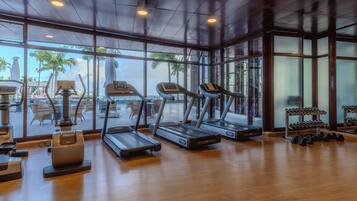 A gym with treadmills, a stationary bike, and dumbbells.