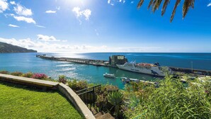 A coastal harbor with a ferry dock, boats, and a clear blue sky. - Pestana Casino Park Ocean and SPA Hotel (Funchal)