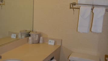 A bathroom with a sink, mirror, toilet, and towel rack.