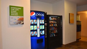 A hallway with a Pepsi vending machine and a snack vending machine. - Motel 6 Anderson, IN - Indianapolis (Anderson)