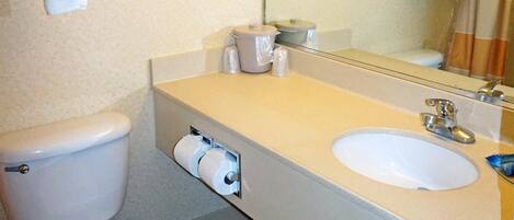 Un baño con inodoro, lavamanos y perchero para toallas.