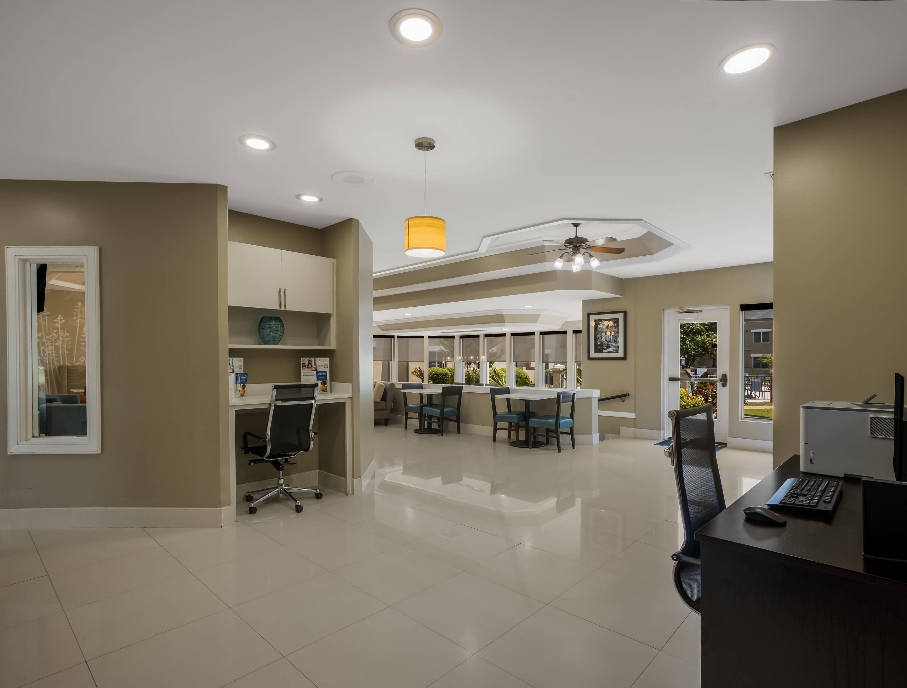 A modern office space with a desk, chairs, and a dining area.