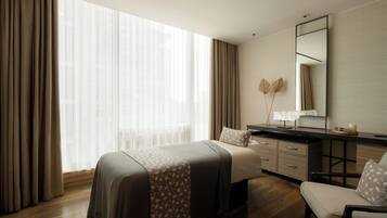 A hotel room with a large bed, a desk, and a chair.