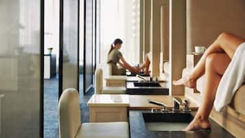 A spa area with individual treatment stations, each equipped with a massage table and a foot bath.