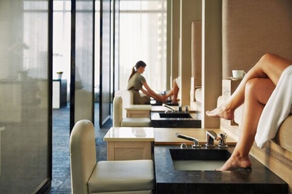 A spa area with individual treatment stations, each equipped with a massage table and a foot bath. - Four Seasons Hotel Toronto (Toronto)