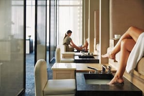 Un espace spa doté de cabines de soins individuelles, chacune équipée d’une table de massage et d’un bain de pieds.