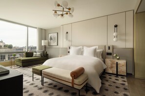 Relax in a serene space with a large bed, side table, and city view.