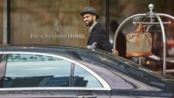 A man stepping out of a car in front of the Four Seasons Hotel.