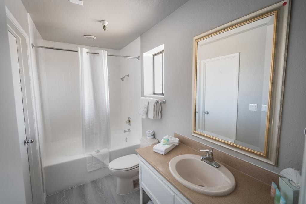 Een moderne badkamer met een bad, toilet en wastafel.