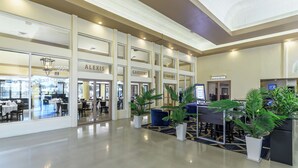 A hotel lobby with multiple dining areas, including a restaurant and a bar & grill. - Alexis Park All Suite Resort (Las Vegas)