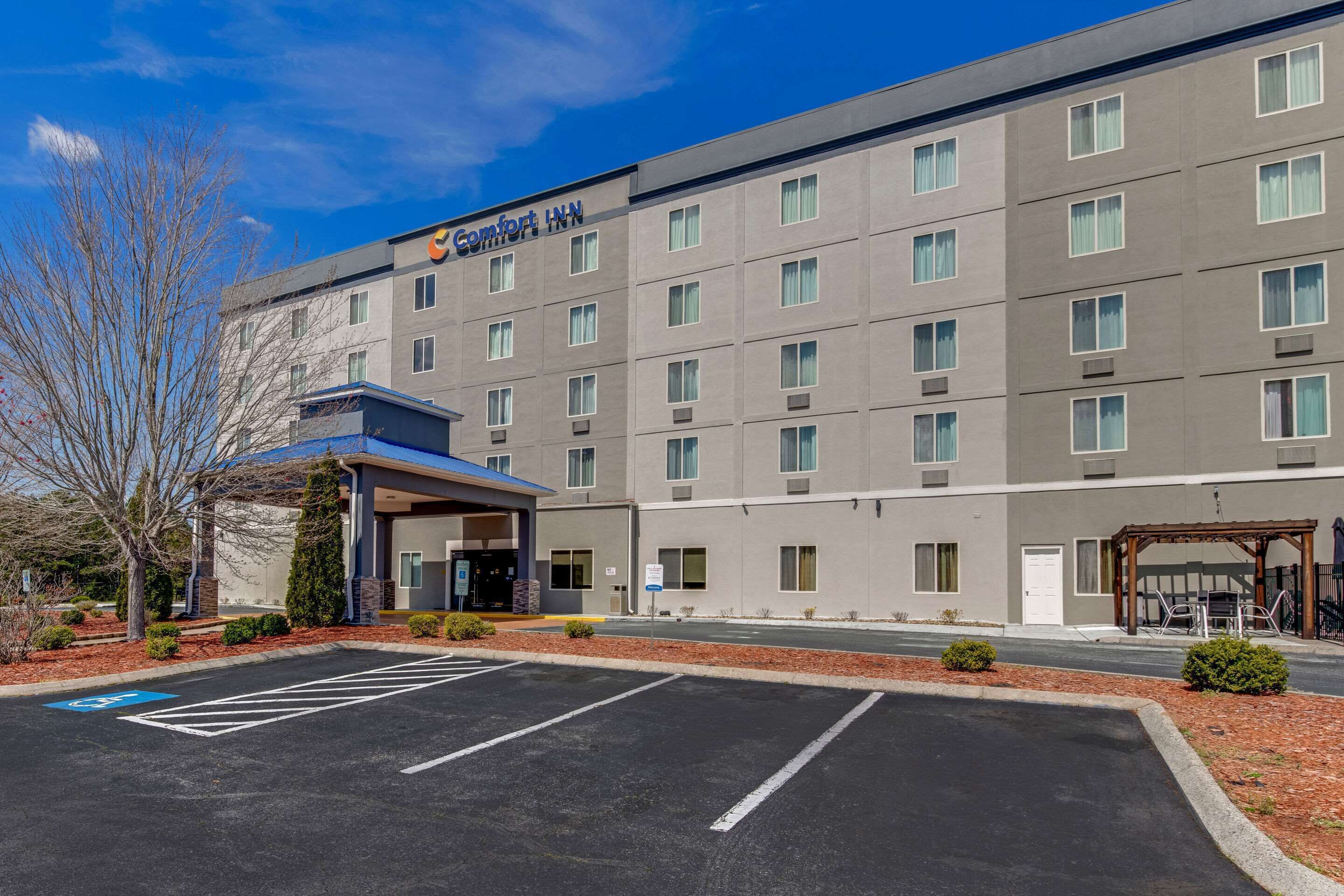 A Comfort Inn hotel with a modern facade, a covered entrance, and a parking lot with handicapped spaces.