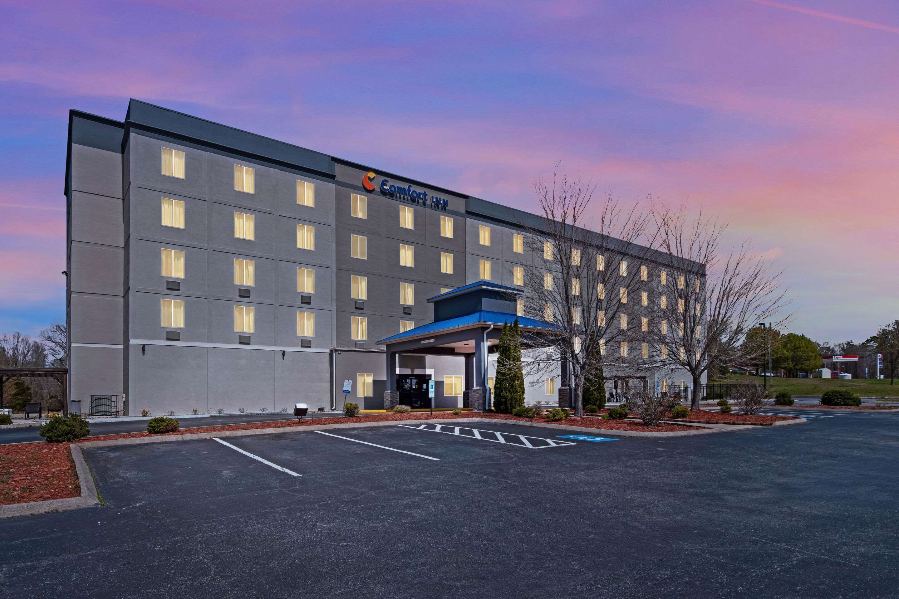 Un hotel Comfort Inn con fachada moderna, un acceso cubierto y un estacionamiento.