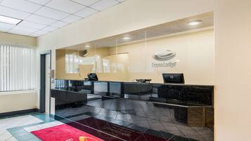 A hotel reception area with a reception desk, a computer, and a sign that reads "Econo Lodge".