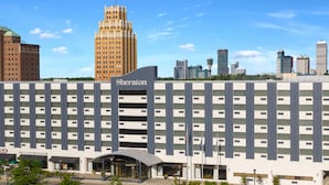 A Sheraton hotel with a modern design, featuring a large parking garage and a Starbucks Coffee outlet. - Sheraton Niagara Falls (Niagara Falls)