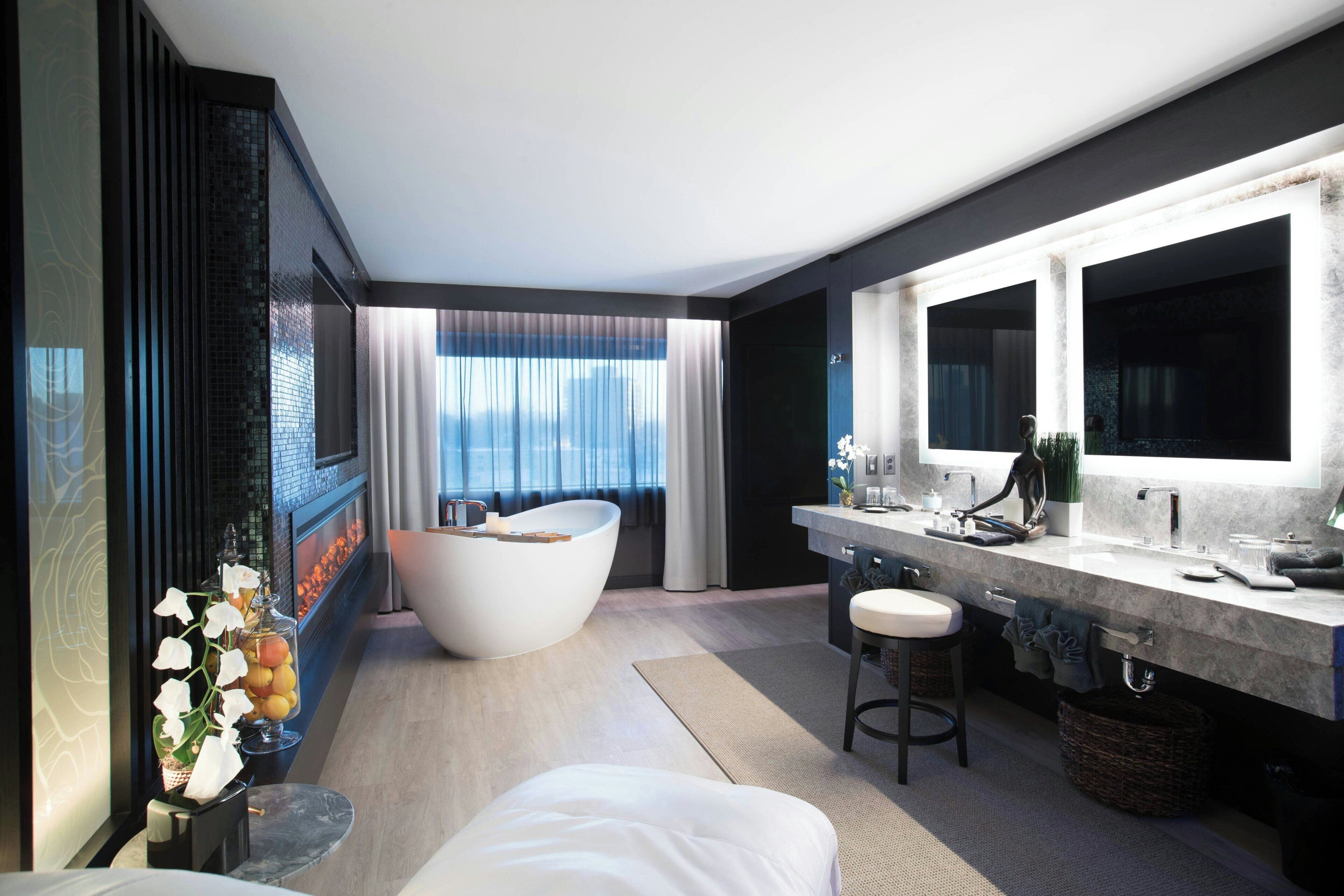 A modern bathroom with a freestanding bathtub, a large mirror, and a vanity with a sink.