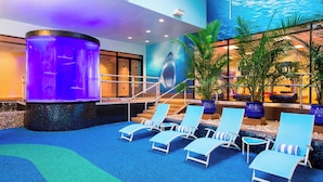 A pool area with lounge chairs, a water feature, and a mural of a shark. - Sheraton Niagara Falls (Niagara Falls)