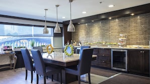 A modern kitchen with a large island, pendant lighting, and a view of the city. - Sheraton Niagara Falls (Niagara Falls)