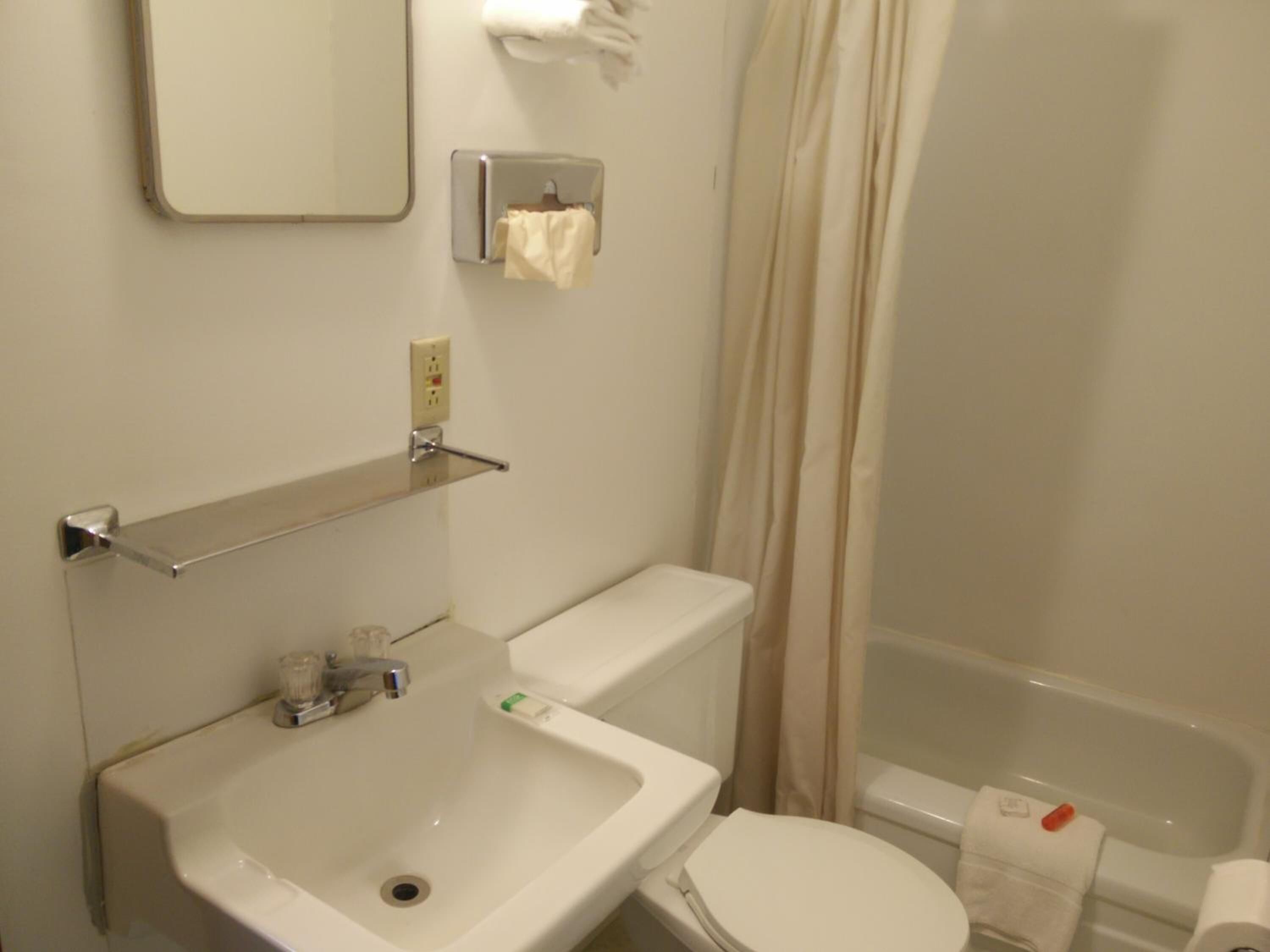 Une salle de bain équipée d’un lavabo, de toilettes et d’un rideau de douche.