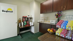 A breakfast area with a coffee machine, Folgers coffee, and a fruit bowl. - Days Inn by Wyndham Riverside Tyler Mall (Riverside)