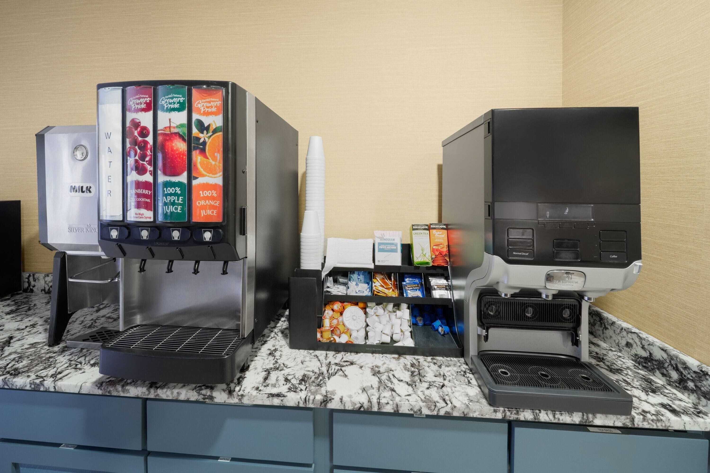 Eine Kaffeemaschine mit verschiedenen Getränkeoptionen und eine Kaffeemaschine auf einer Marmorarbeitsplatte.