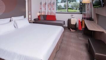 Una habitación de hotel con una cama grande, un sofá, un escritorio y una televisión.