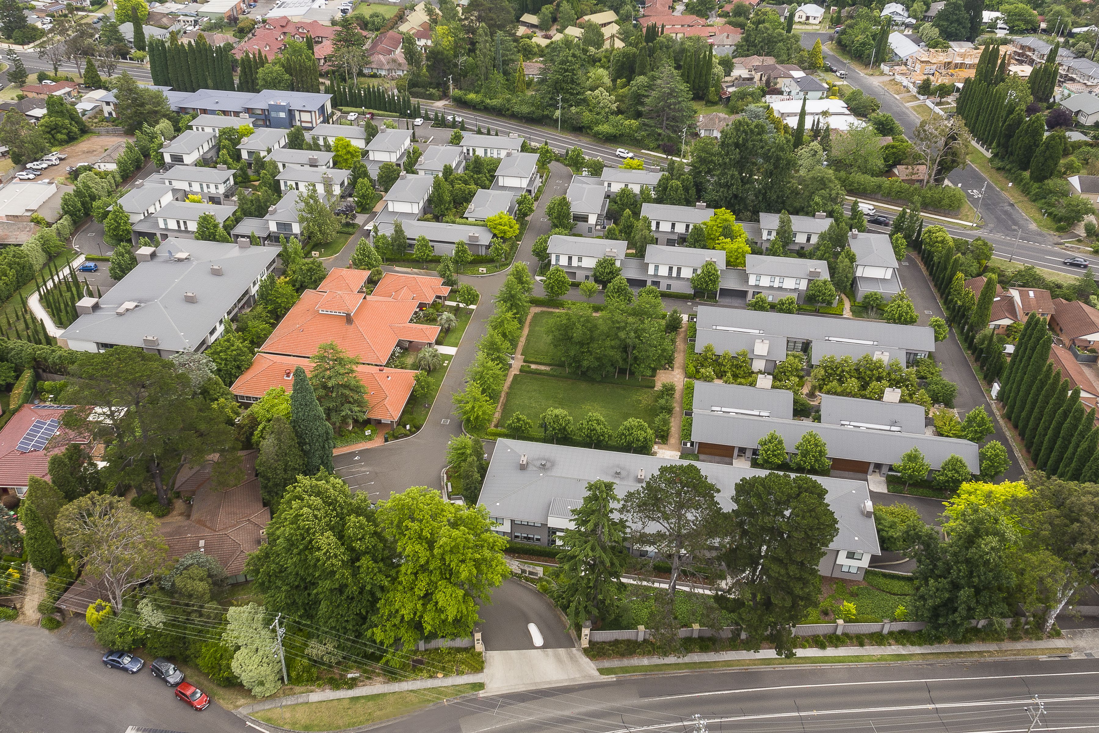 Vue aérienne d’un quartier résidentiel avec de nombreuses maisons, des rues et des espaces verts.