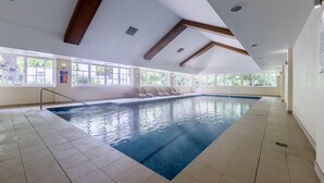 An indoor swimming pool with clear blue water, wooden beams on the ceiling, and large windows providing natural light. - The Sebel Bowral Heritage Park (Bowral)
