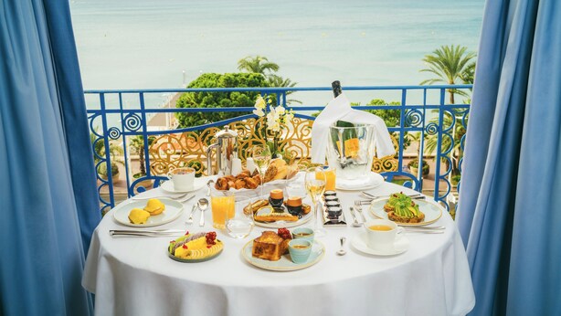 A table set for breakfast with a view of the sea.