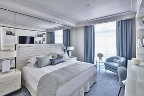 Relax in a spacious room with a large bed, nightstand, and comfortable armchair.