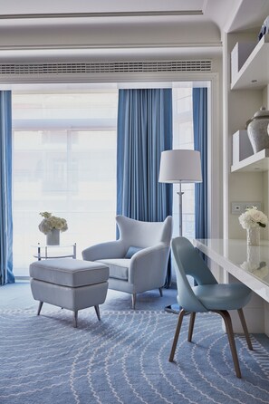 Relax in a serene space with a large window, comfortable seating area, and a stylish console table.