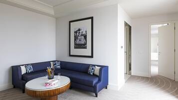 Un salon moderne avec un canapé bleu, une table basse ronde et un tableau encadré accroché au mur.
