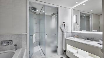Un baño moderno con cabina de ducha de vidrio, bañera y tocador con un espejo grande.
