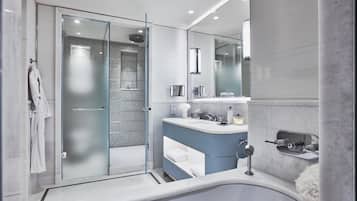 A modern bathroom with a glass-enclosed shower, a freestanding bathtub, and a vanity with a mirror.