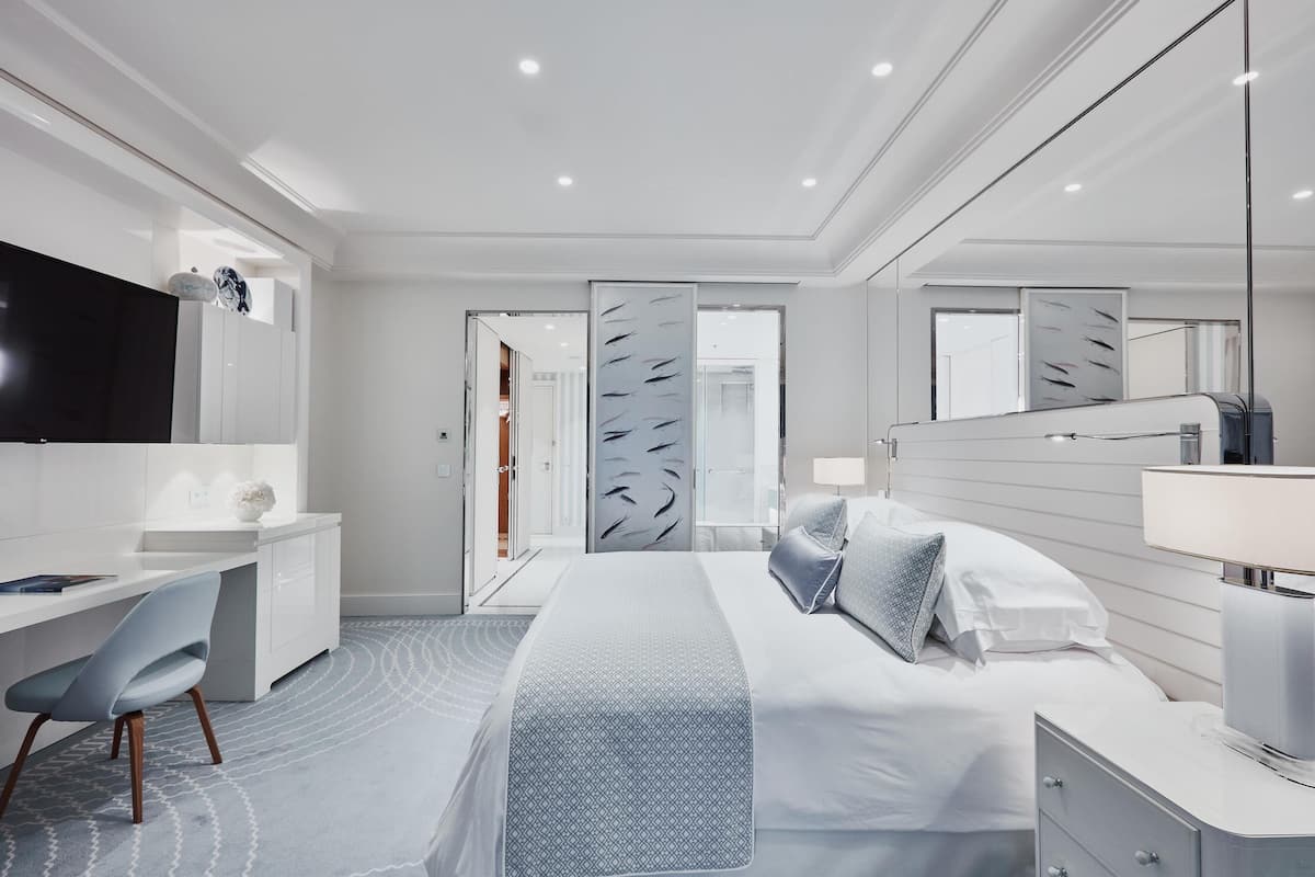 Une chambre d’hôtel moderne avec un grand lit, un bureau et une télévision.