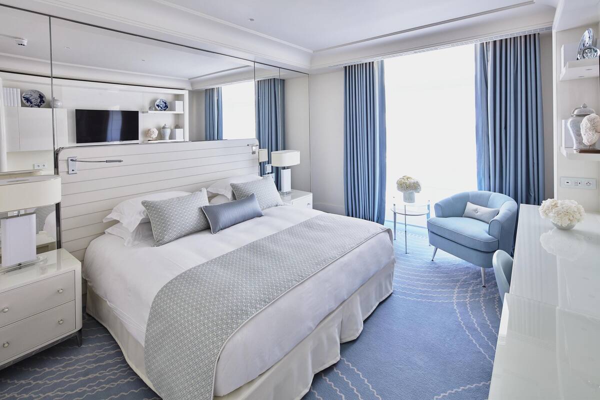 Une chambre d’hôtel moderne équipée d’un grand lit, d’un bureau, d’une chaise et d’un téléviseur.