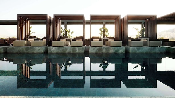 A modern pool area with tiered seating and large windows. - Radisson Blu Park Hotel, Athens (Athens)