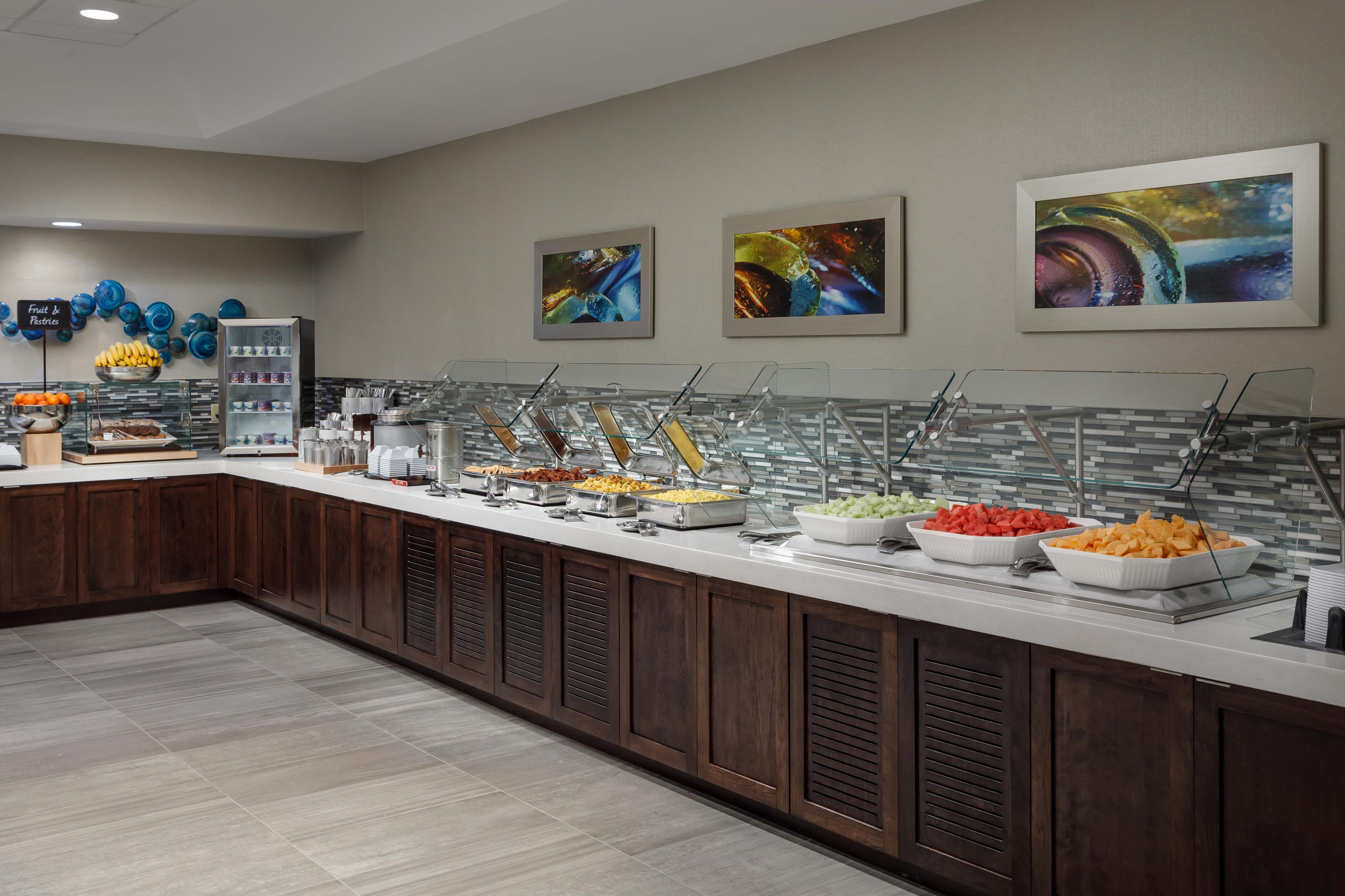 Un buffet proposant une variété de plats et une sélection de fruits et de pâtisseries.