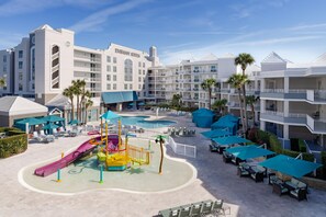Un hôtel doté d’un espace piscine comprenant un toboggan et des chaises longues.